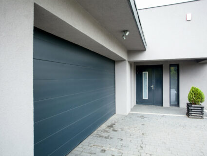 new grey sectional garage door beside aluminium front door