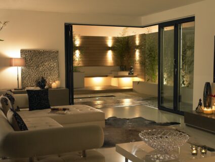 origin bifold doors fully open at night to a lit patio