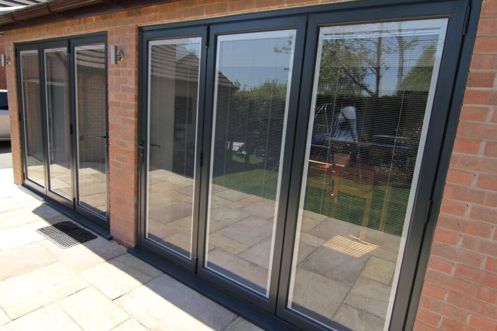 Grey bifolding doors with between glass blinds fitted