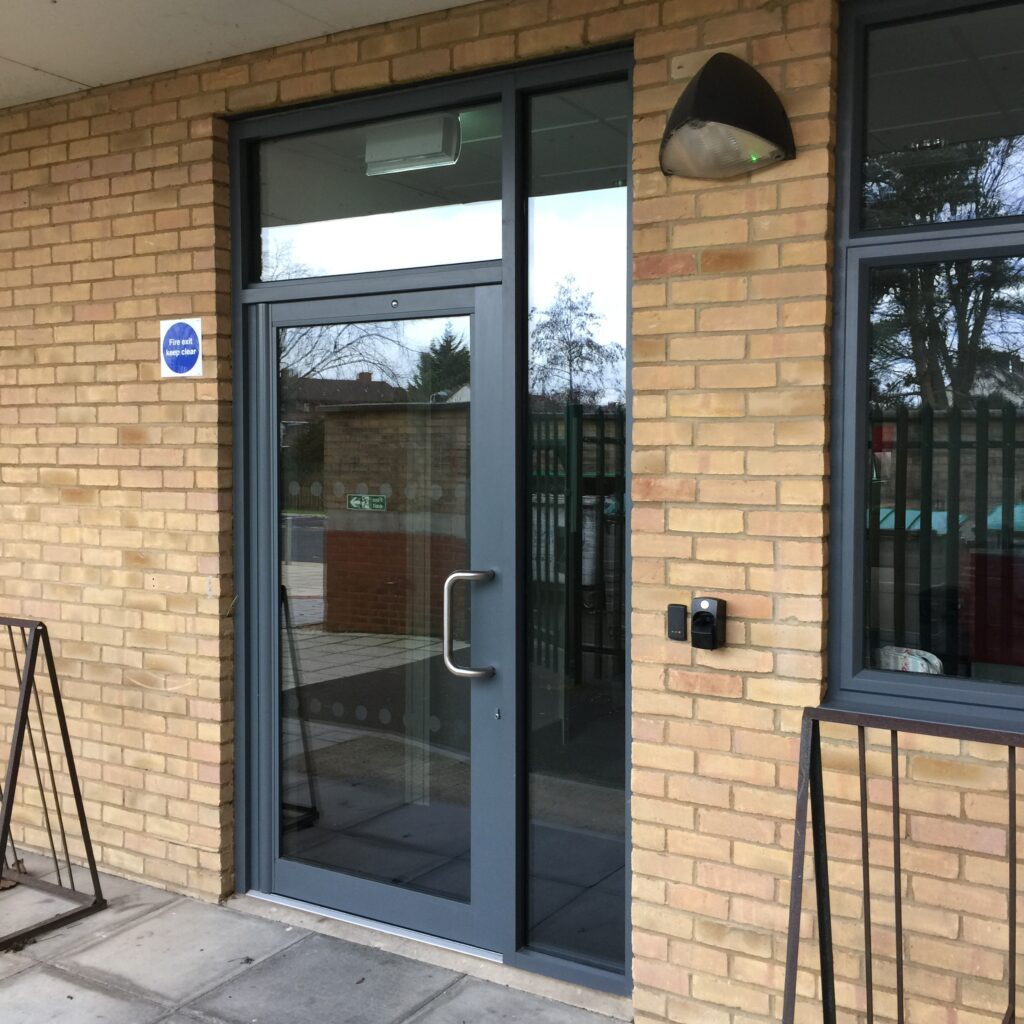 aluminium commercial doors in a brick opening with window on the side